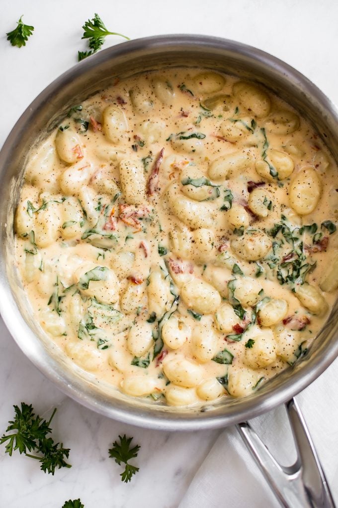 metal skillet with creamy sun-dried tomato spinach gnocchi