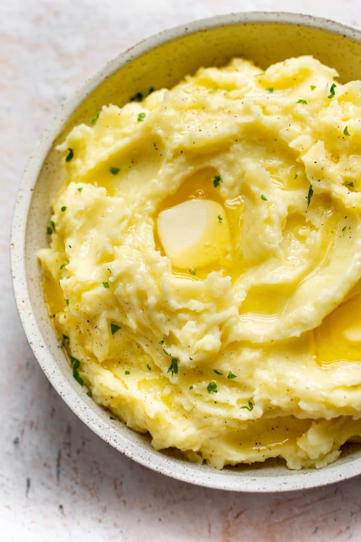 Instant Pot mashed potatoes in a serving bowl with plenty of butter