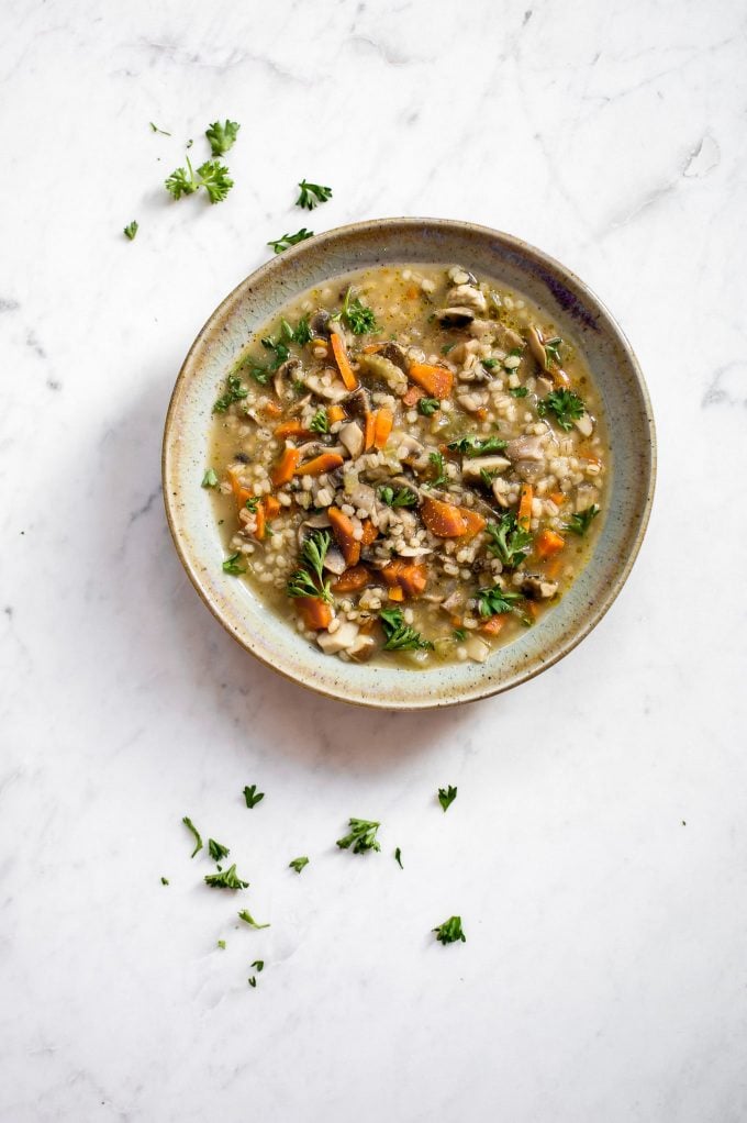 bowl of healthy barley mushroom soup on a marble surface