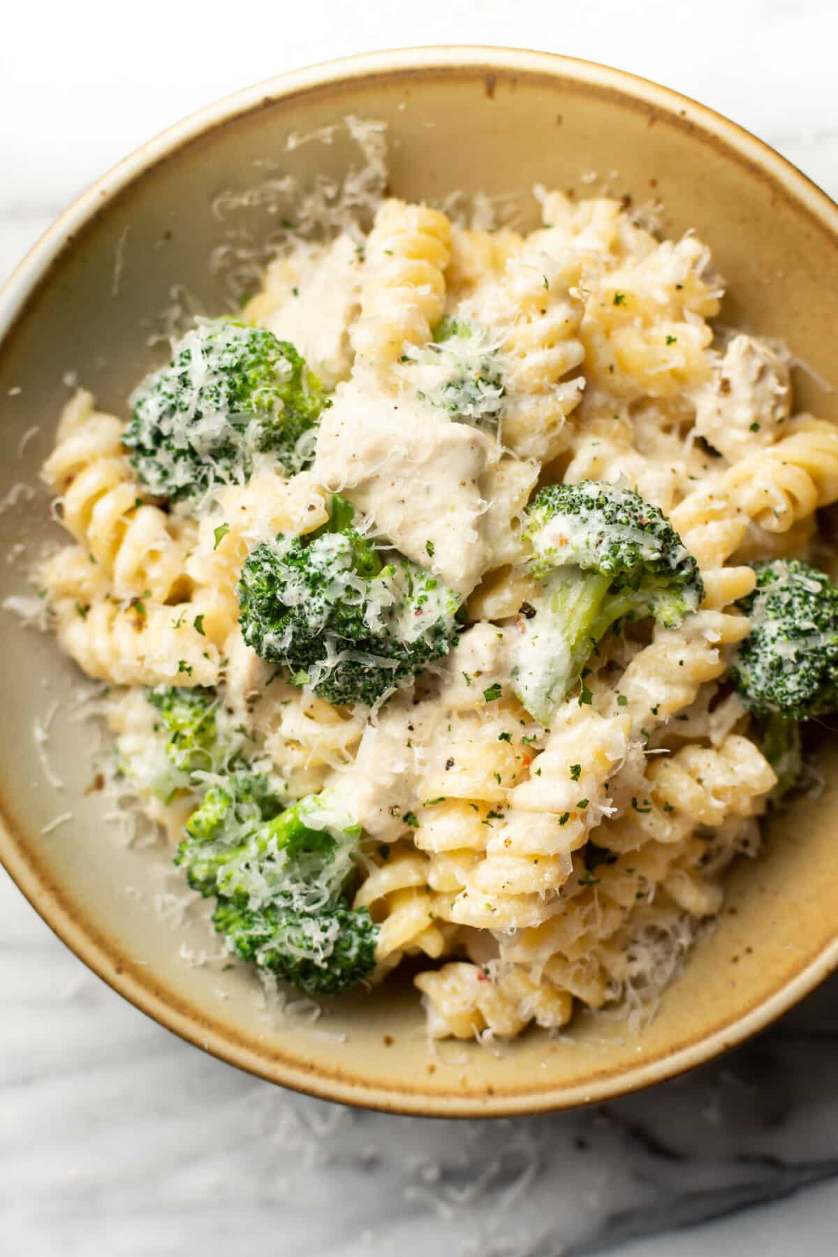 a bowl of chicken and broccoli pasta