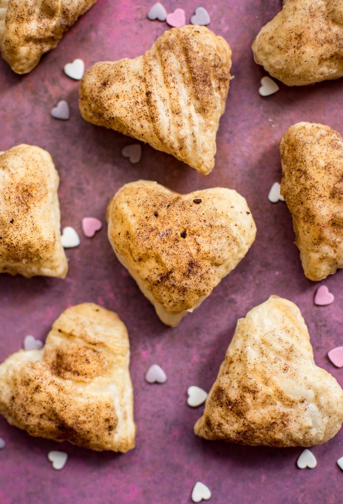 close-up of puff pastry hearts on purple-pink surface