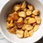 a small bowl with cloves of roasted garlic