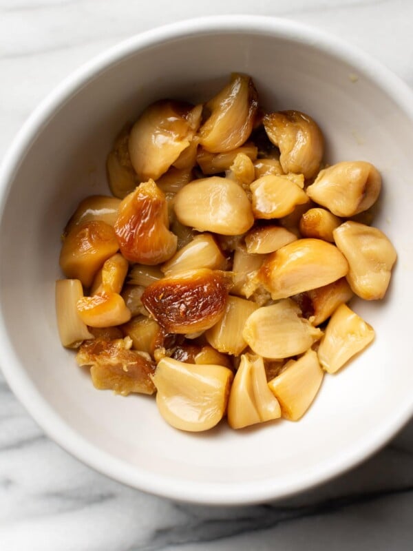 a small bowl with cloves of roasted garlic