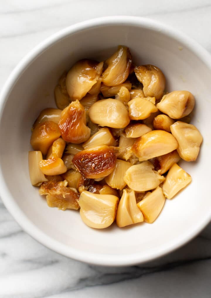 a small bowl with cloves of roasted garlic