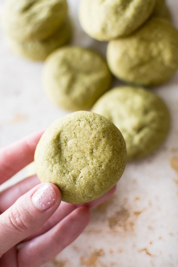 female hand holding a vegan matcha cookie