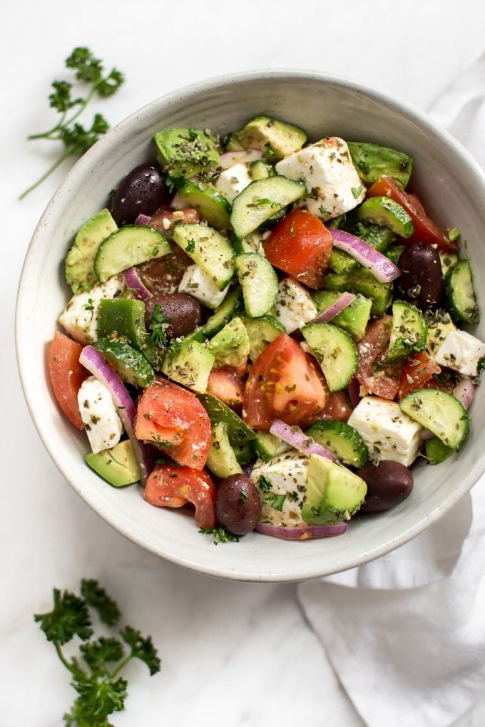 close-up of bowl of easy Mediterranean salad loaded with cucumbers, olives, tomatoes, and feta