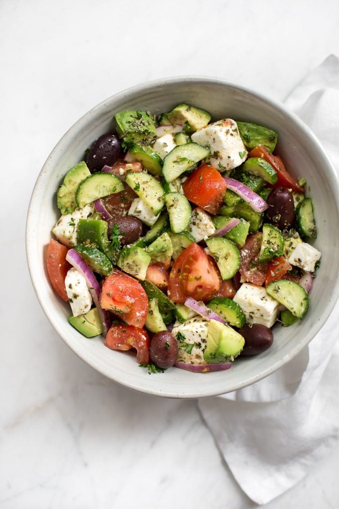 easy avocado Greek salad with Mediterranean flavors in a white bowl