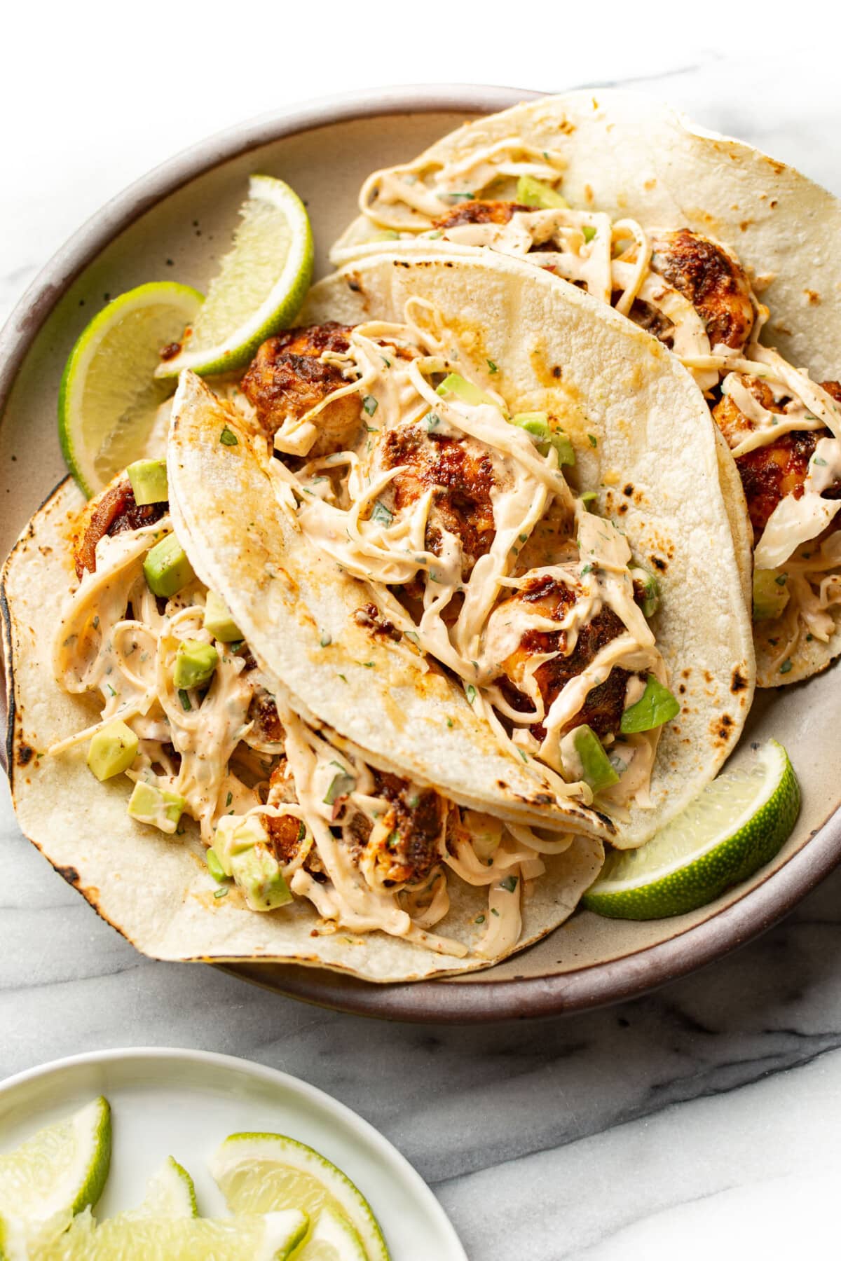 a plate with three blackened shrimp tacos