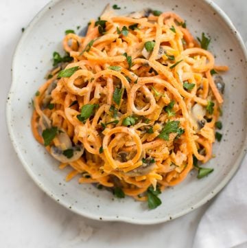 This 20 minute vegetarian creamy mushroom sweet potato noodles recipe is a healthy vegetarian spiralized sweet potato recipe. This recipe will quickly show you how to make sweet potato noodles! The simple garlicky mushroom Alfredo sauce is delicious!