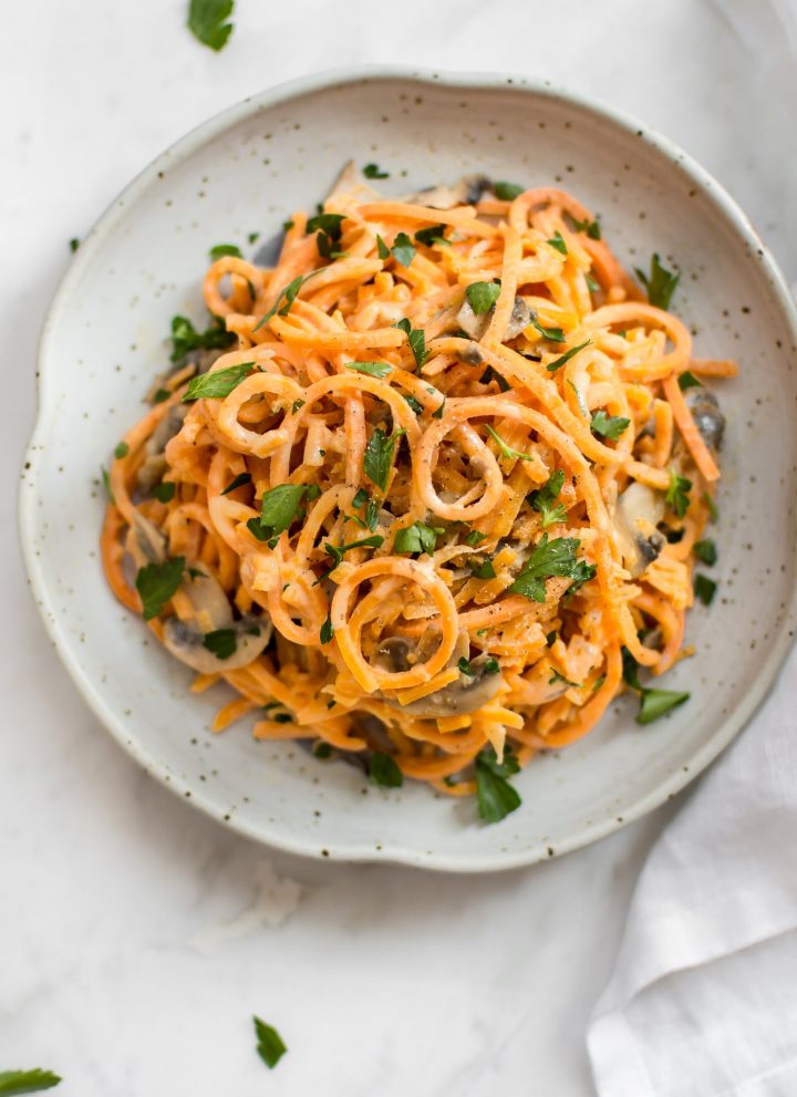 This 20 minute vegetarian creamy mushroom sweet potato noodles recipe is a healthy vegetarian spiralized sweet potato recipe. This recipe will quickly show you how to make sweet potato noodles! The simple garlicky mushroom Alfredo sauce is delicious!