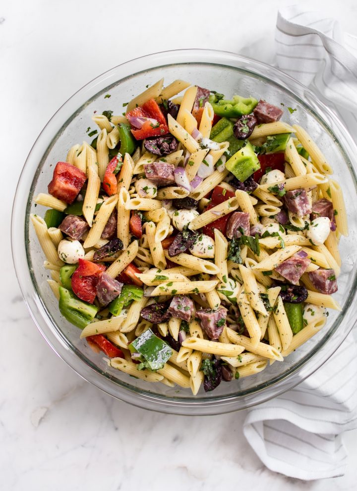 This Italian pasta salad recipe is healthy, fast, and easy to make! It's the best classic cold pasta salad for summer BBQs, picnics, or potlucks. A tangy vinaigrette, salami, mozzarella, and fresh herbs make this one delicious side dish! Feeds a crowd. 