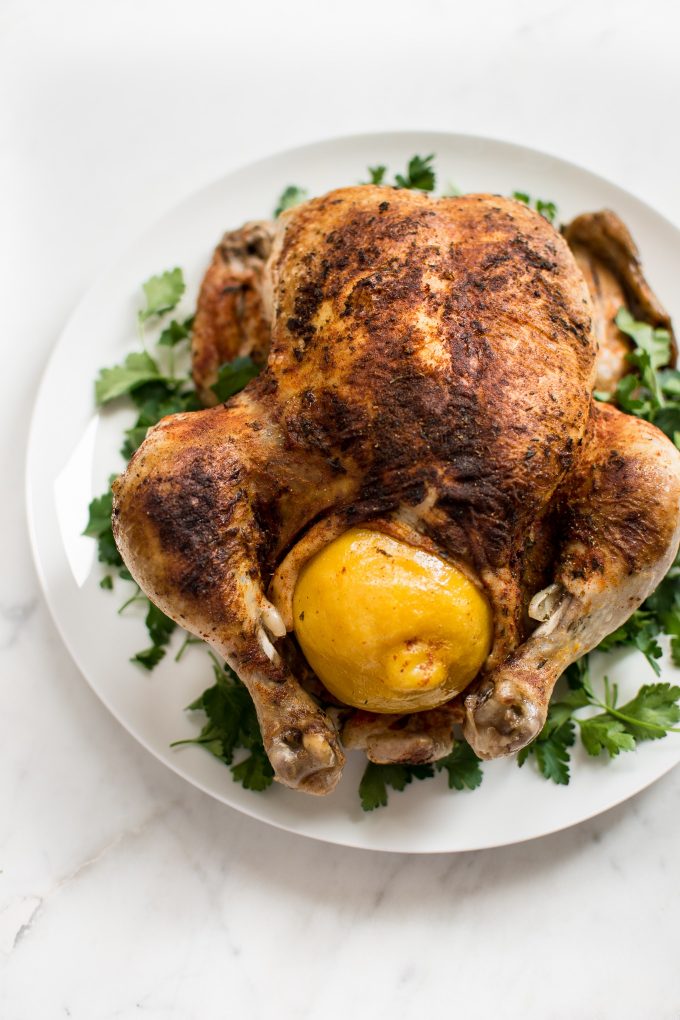 whole chicken with lemon on a serving plate