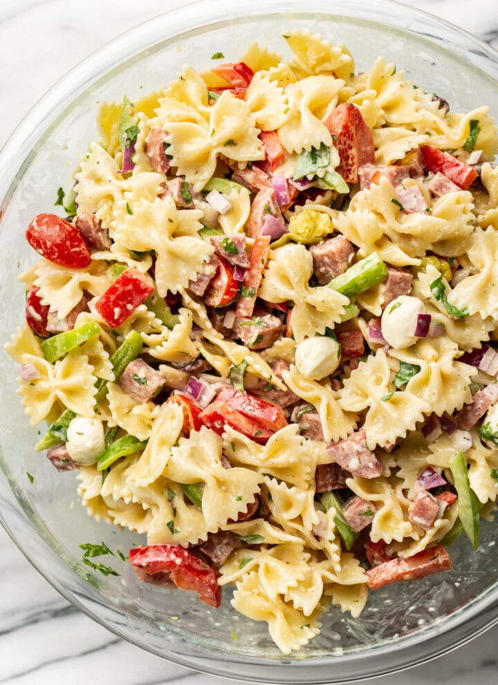 a glass bowl with italian pasta salad