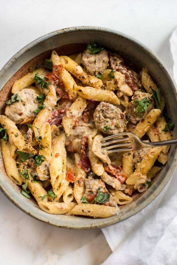close up of Cajun sausage penne with a fork