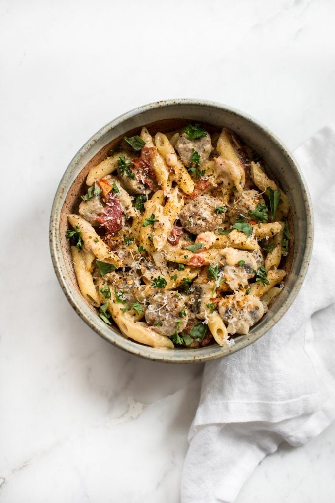 Cajun sausage pasta in a bowl on a marble surface