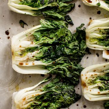 This roasted baby bok choy recipe makes a quick, easy, healthy, and delicious side dish! Garlic, lemon juice, spicy chili flakes, and soy sauce make this side dish extra tasty. Easily cooked in the oven in 10 minutes! A simple vegan recipe. 