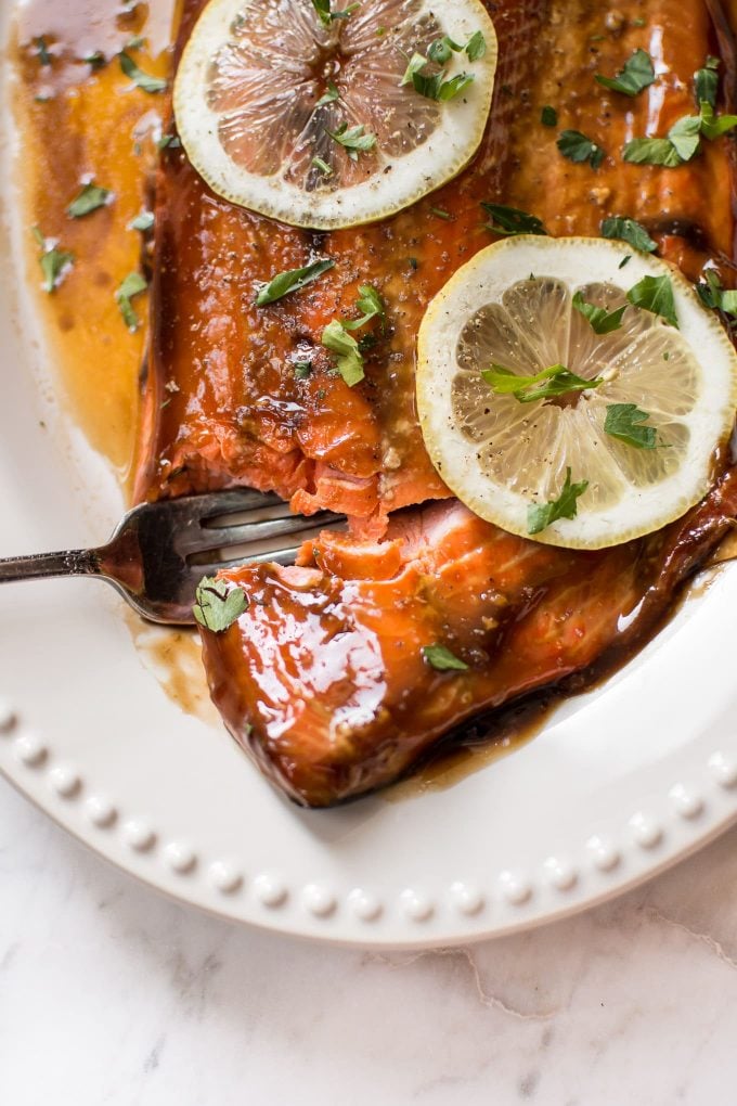 close-up of baked teriyaki salmon with a fork and lemon slice