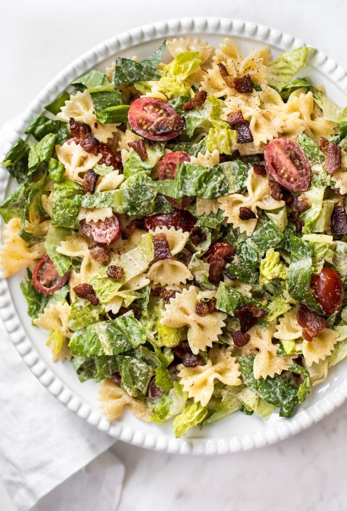 BLT pasta salad with bowtie shaped pasta on a white plate