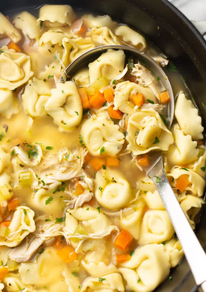 a ladle in a pot of chicken tortellini soup