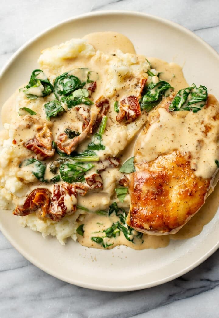 a plate with mashed potatoes and creamy tuscan chicken