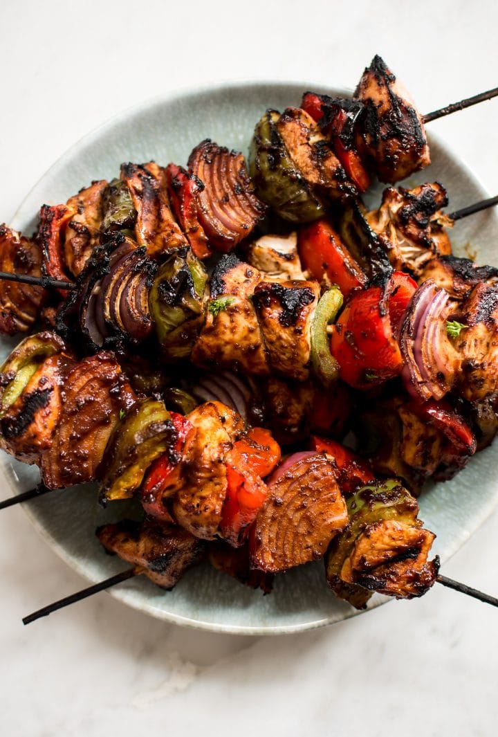 close-up of marinated grilled chicken and vegetable kabobs on a plate