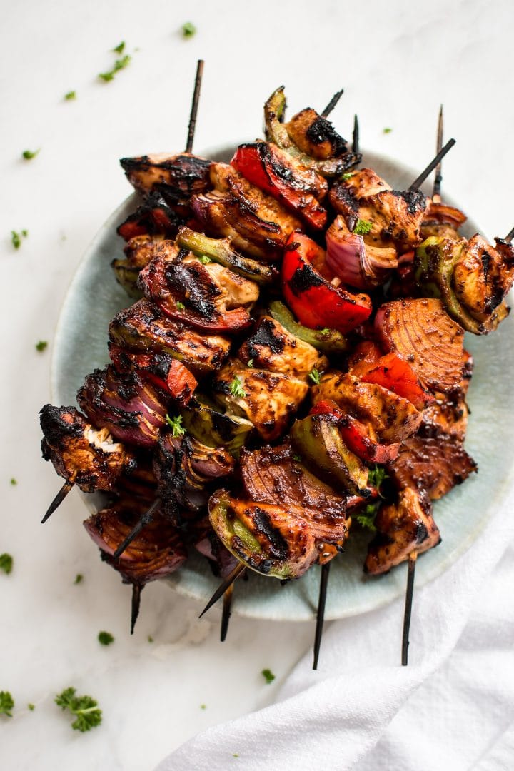 several easy grilled chicken skewers on a teal plate