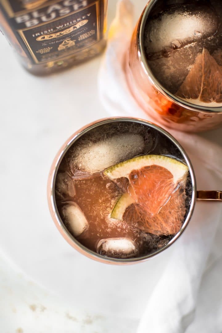 close-up of grapefruit Irish mule cocktail with grapefruit slices and ice in a copper mug