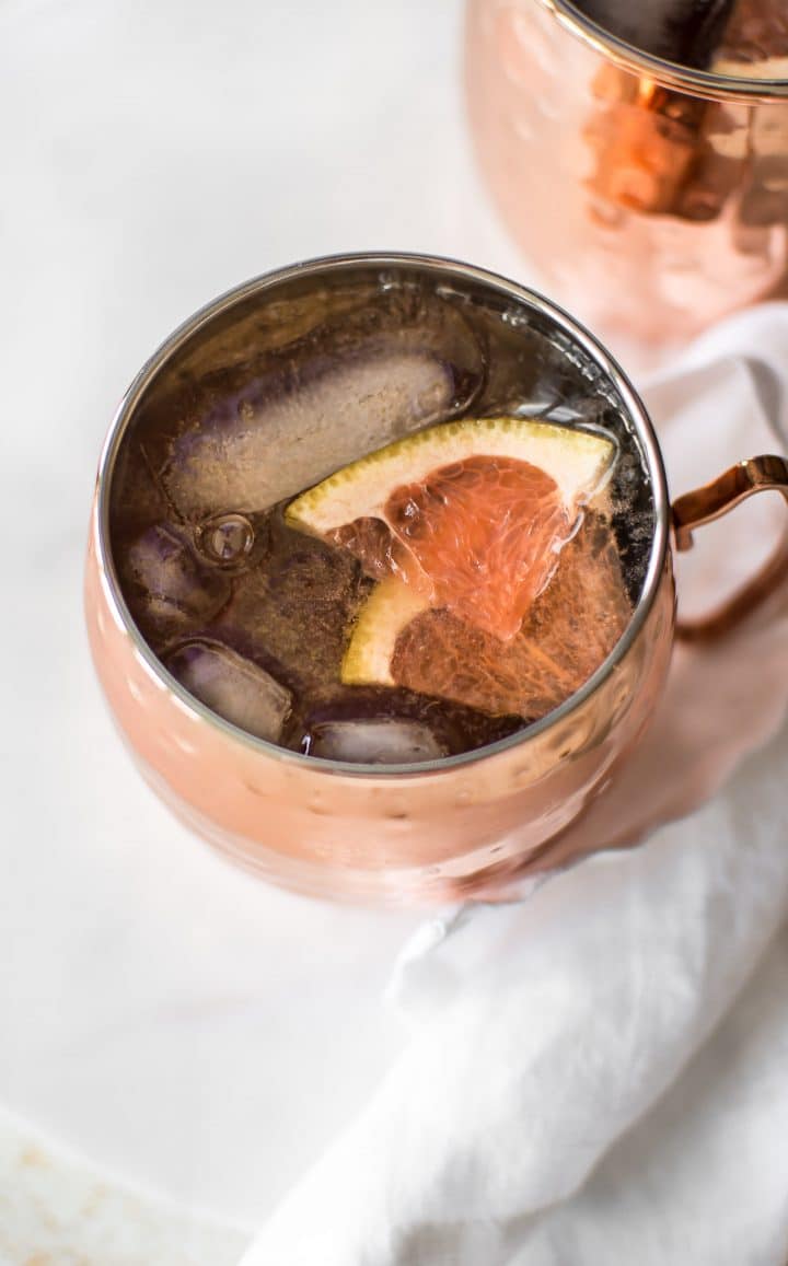 close-up of grapefruit Irish mule cocktail in a mug on the rocks with grapefruit slices