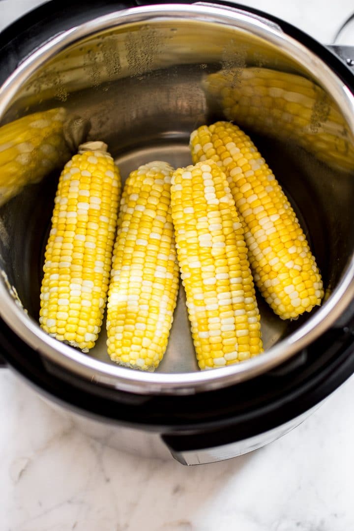 four corn cobs inside an Instant Pot
