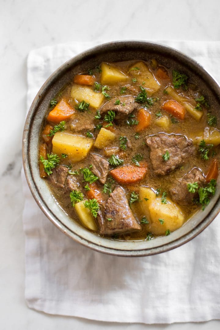 bowl of Irish Instant Pot stew with carrots and potatoes on a marble surface