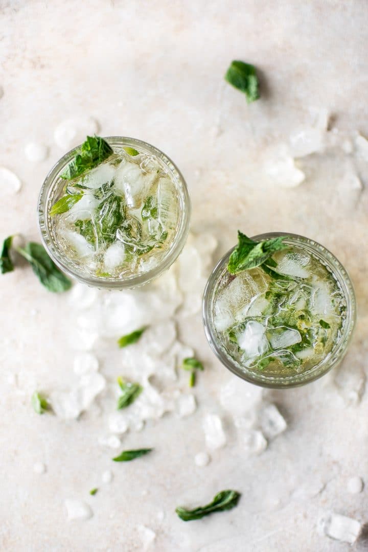 two glasses with mint julep cocktails garnished with mint sprigs
