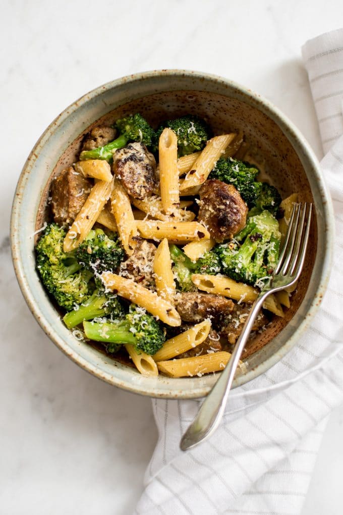 close-up of sausage broccoli pasta in a bowl with a fork