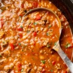 close-up of a ladle of stuffed pepper soup in a pot