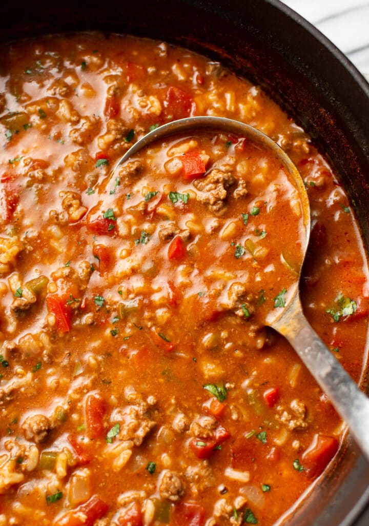 close-up of a ladle of stuffed pepper soup in a pot