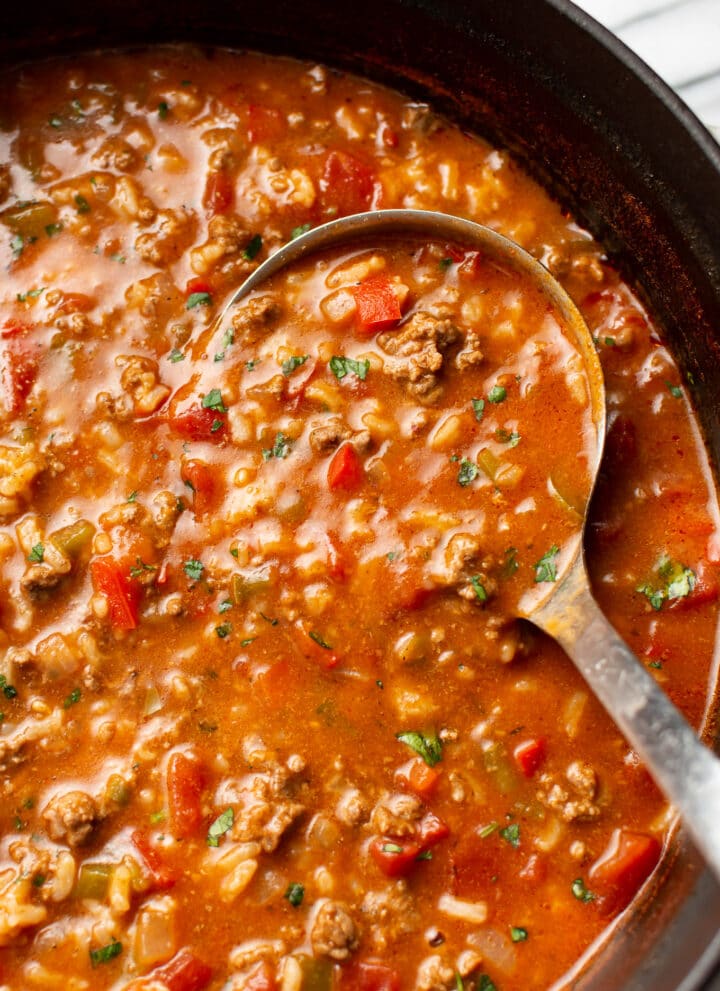 close-up of a ladle of stuffed pepper soup in a pot