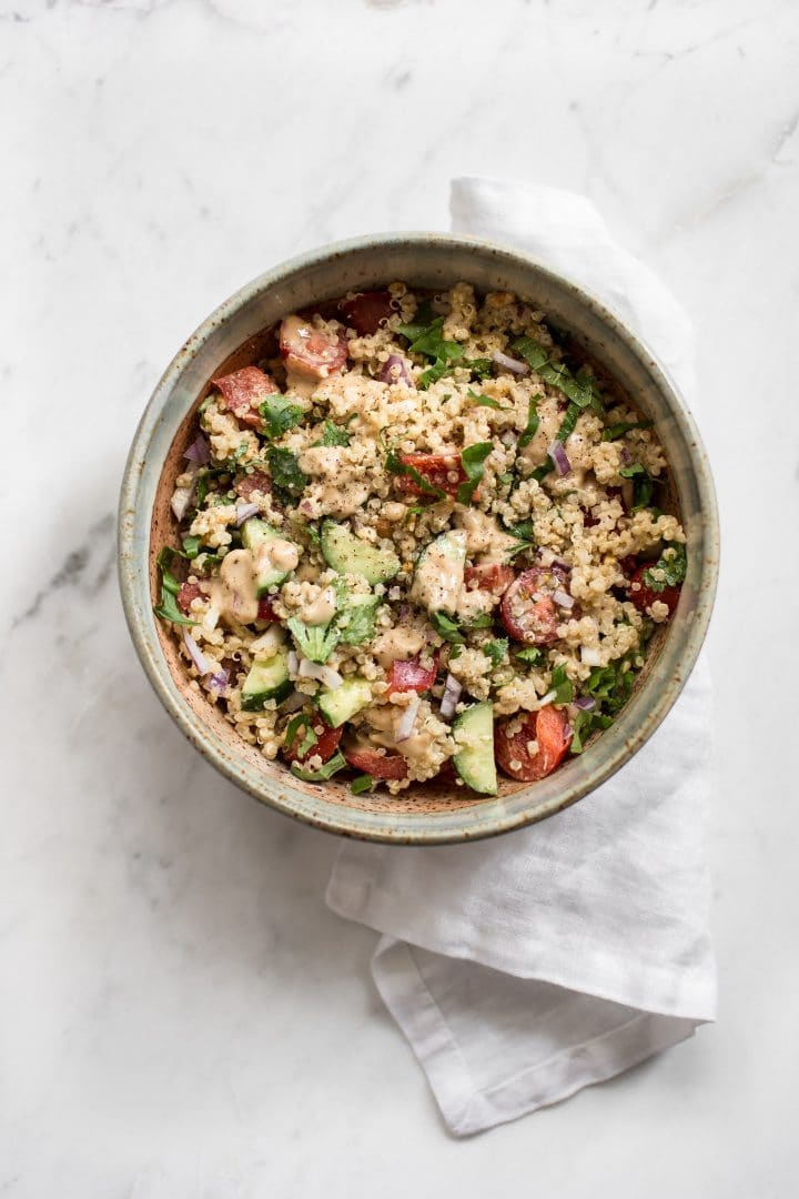 bowl with vegan Thai inspired quinoa salad with cucumbers and tomatoes