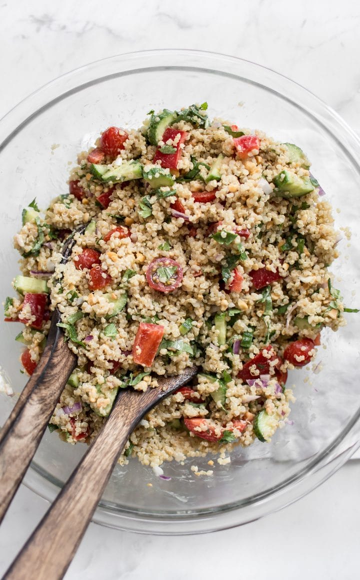 glass bowl with Thai quinoa salad and wooden serving utensils