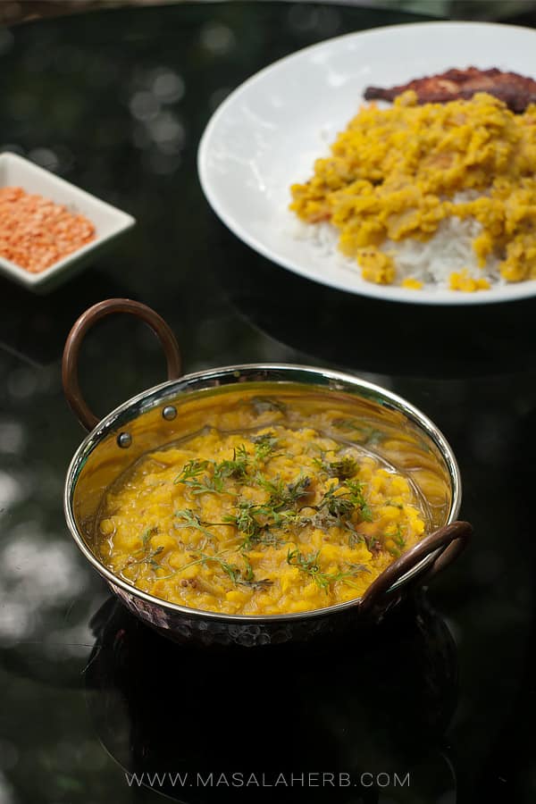 vegan dal in a pot beside a plate of dal over rice