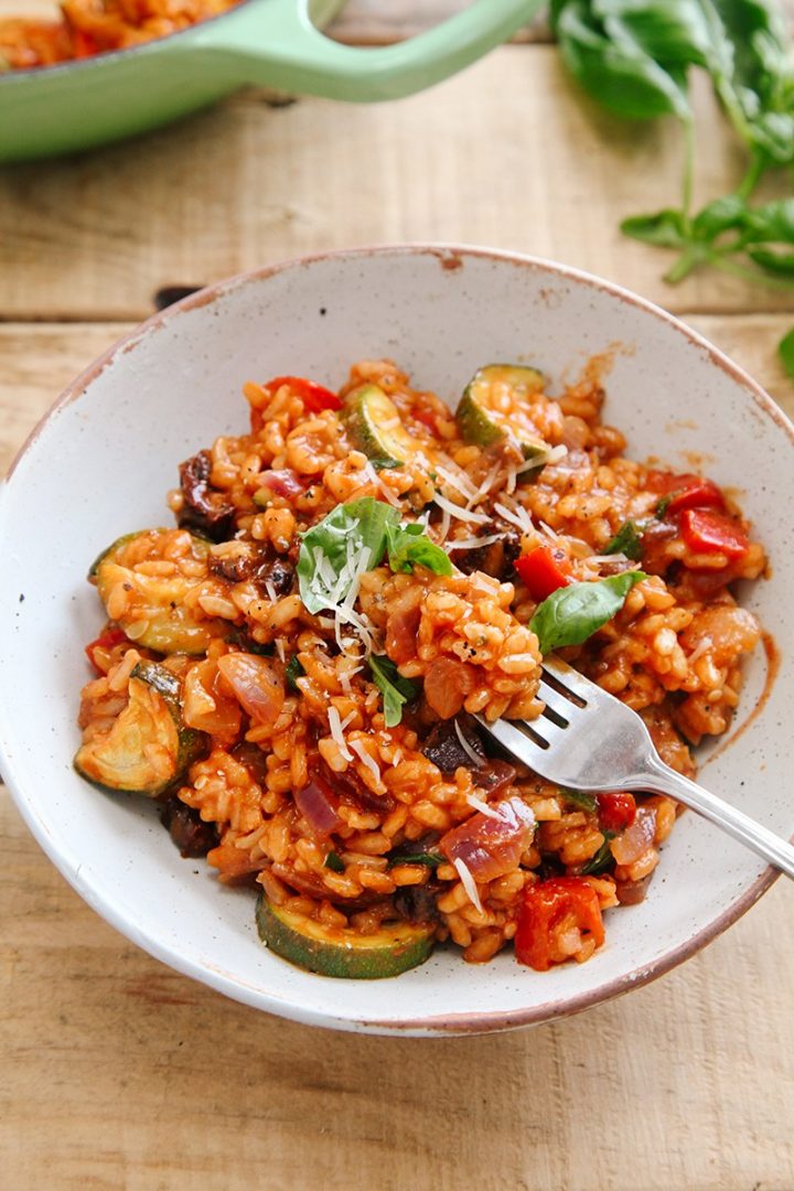 vegan tomato risotto in a bowl with a fork