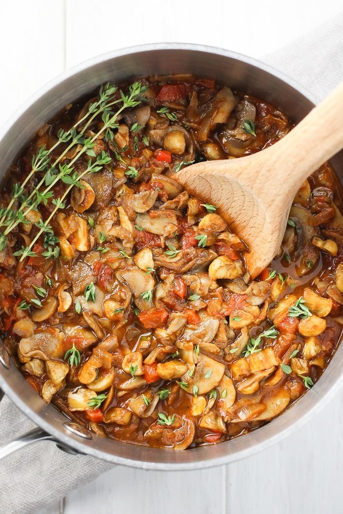 vegan mushroom goulash in a pot with a wooden serving spoon