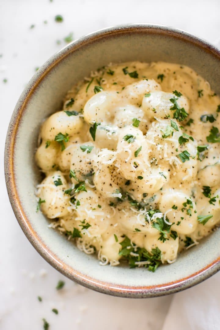 close-up of bowl of gnocchi with parmesan garlic sauce