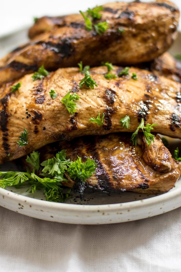 close-up of balsamic grilled chicken on a plate with parsley garnish