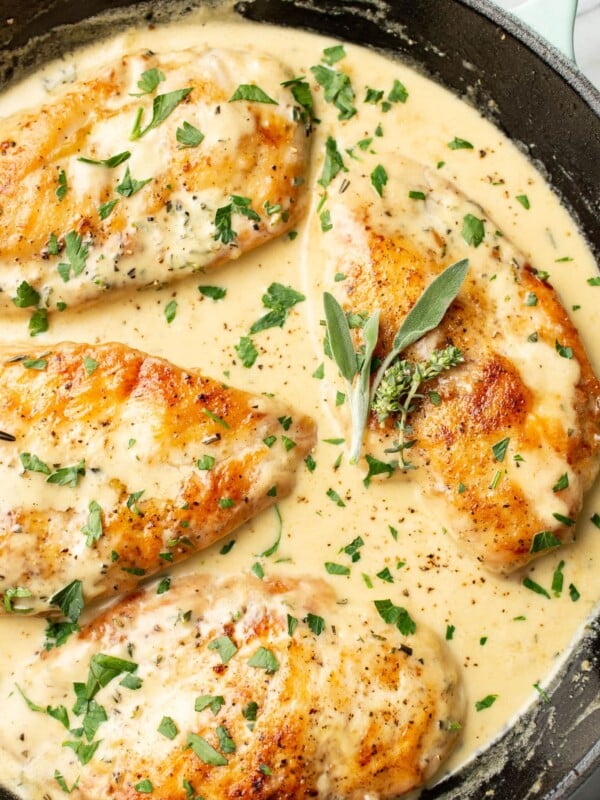 a skillet with chicken in a creamy herb sauce