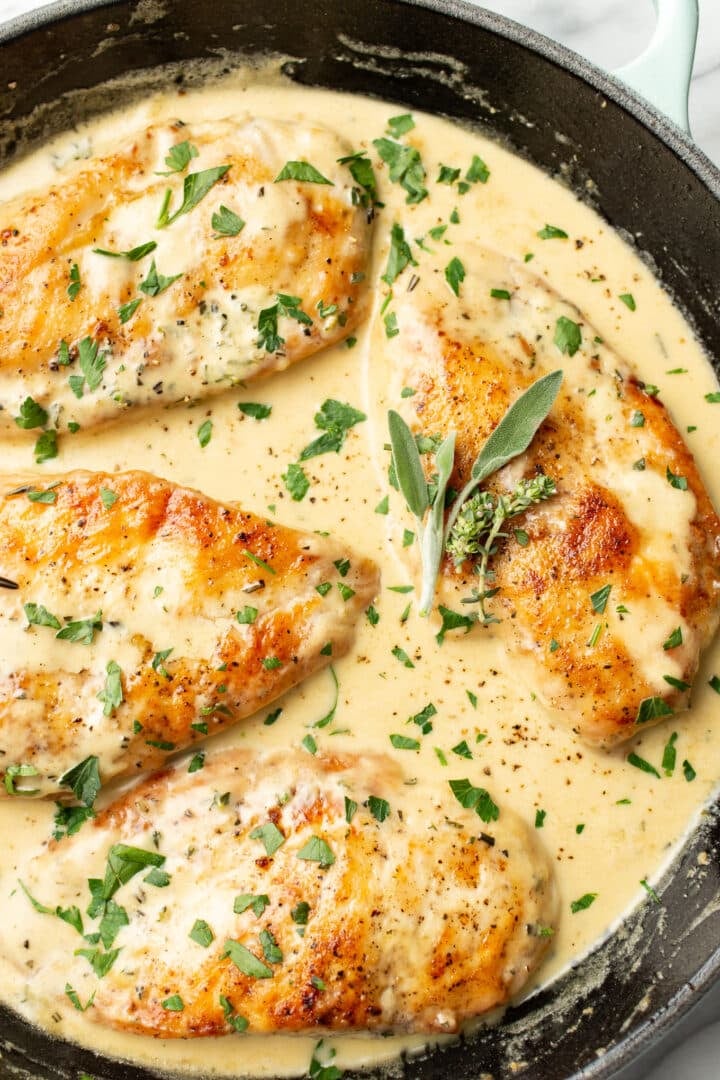 a skillet with chicken in a creamy herb sauce
