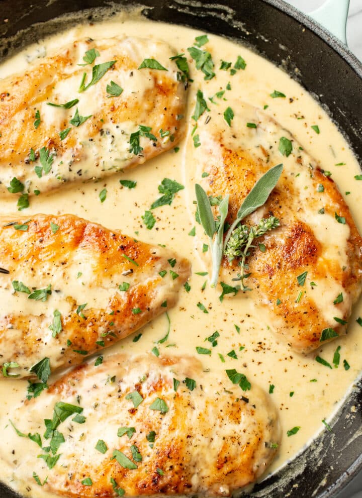 a skillet with chicken in a creamy herb sauce