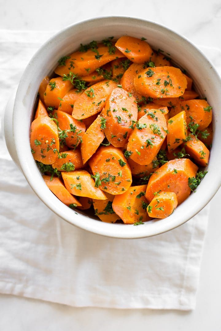 bowl of Instant Pot honey carrots by a cloth napkin