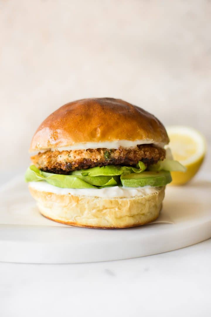 easy salmon burger in a bun on a board with lemon in the background