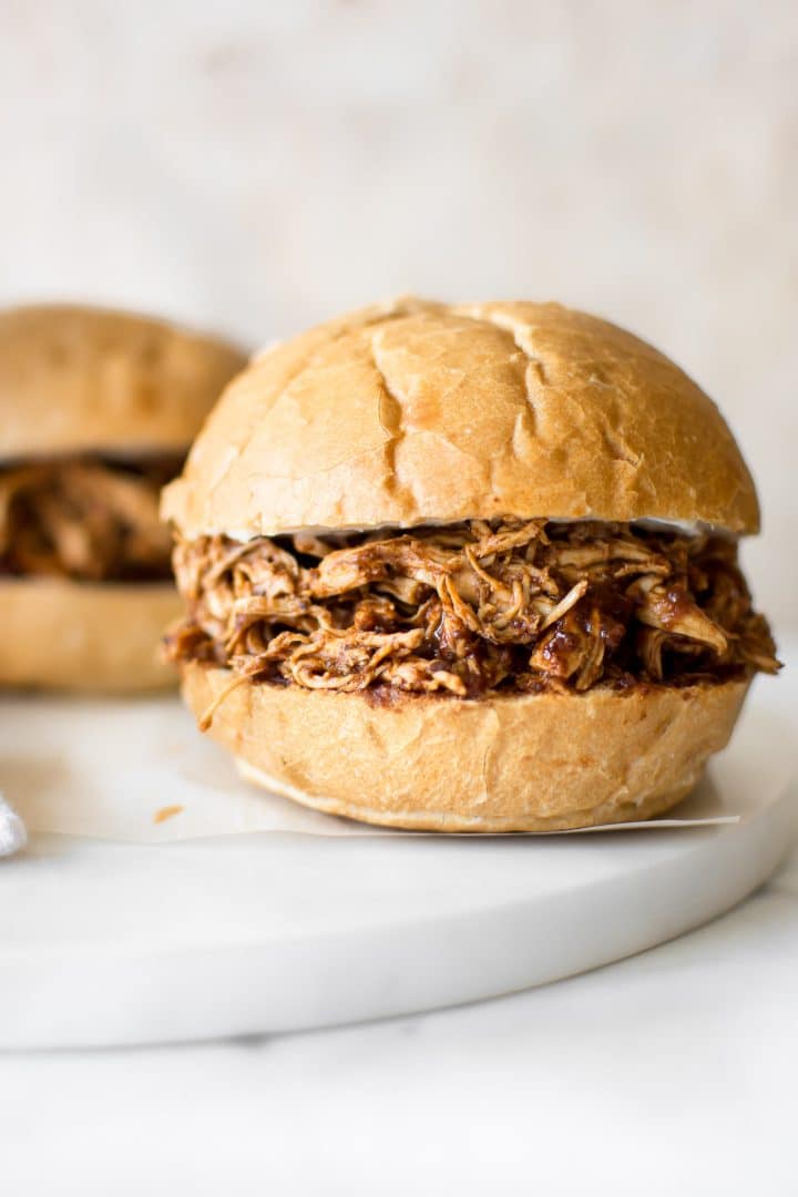 close-up of pulled BBQ chicken sandwich on a bun