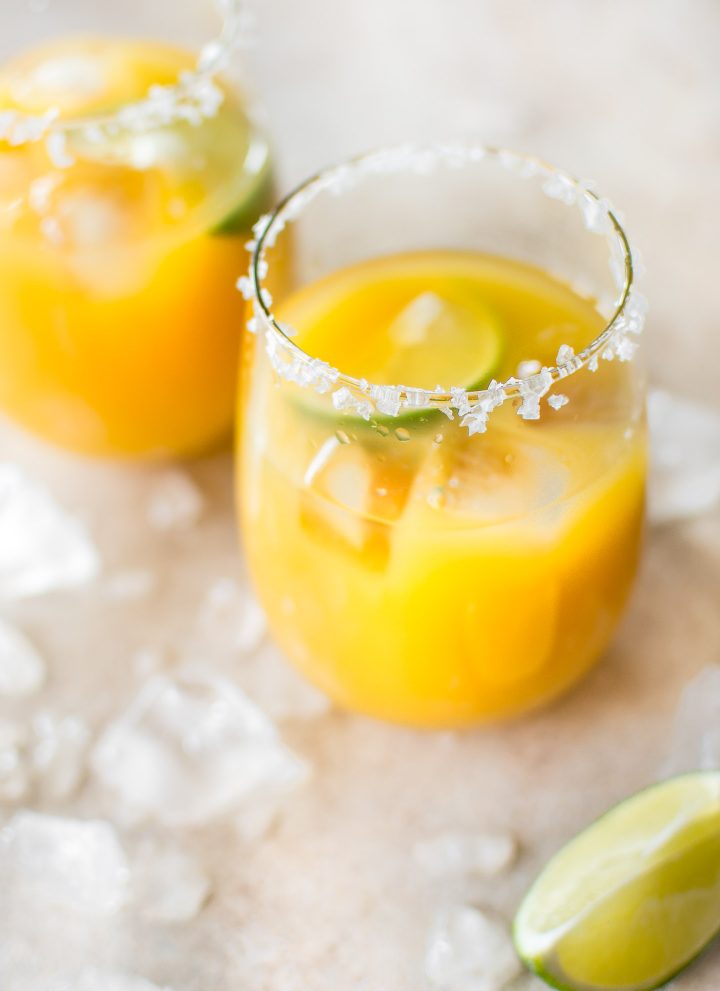 Homemade mango margaritas on the rocks are easy to make and refreshing in the summer! Dust off that tequila and try this simple fruity margarita today.