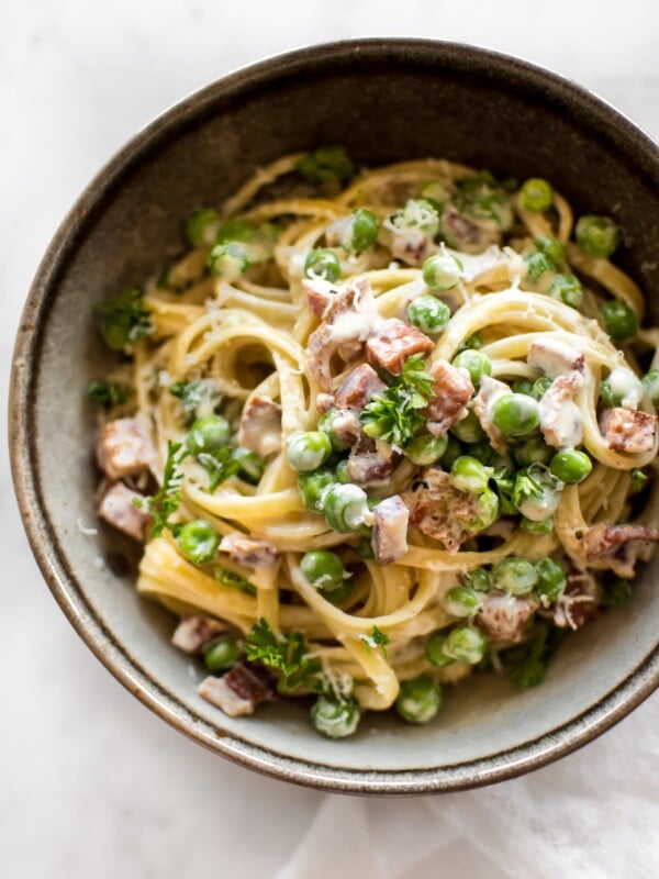 Pasta with pancetta, peas, a creamy garlic sauce, and plenty of fresh parmesan makes an easy and tasty dinner!